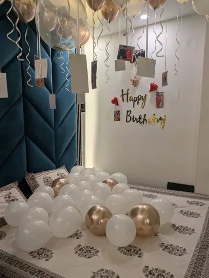 A close-up of the balloons on the bed and the personalized photo wall, a truly heartfelt surprise.