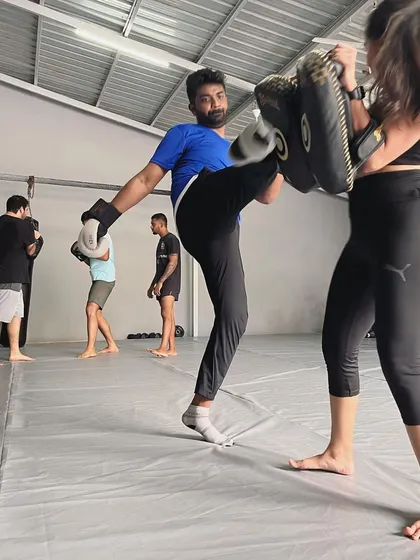 A powerful kick connects with the pads during a weekend class.