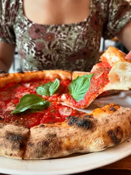 Enjoying a slice of our Marinara pizza. The crust is just as important as the sauce.