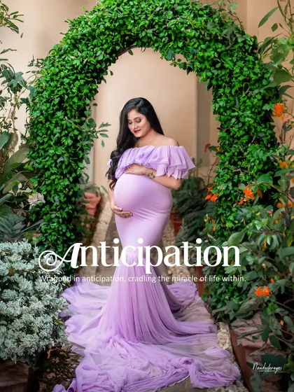 The word "Anticipation" perfectly describes this image. The mother-to-be stands under a green arch, lost in thought about the future.