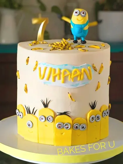 A fun Minions-themed cake surrounded by a crowd of little fondant minions. A larger minion figure stands on top, making it a perfect cake for fans of the yellow characters.