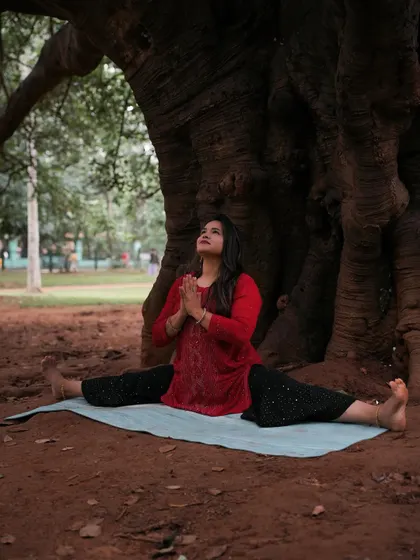 A moment of peace and gratitude in a wide-legged seated pose (Upavistha Konasana) under a large tree.