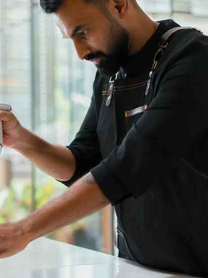Chef Vinesh Johny uses an immersion blender to emulsify a chocolate ganache, a critical technique for achieving a smooth and stable texture.