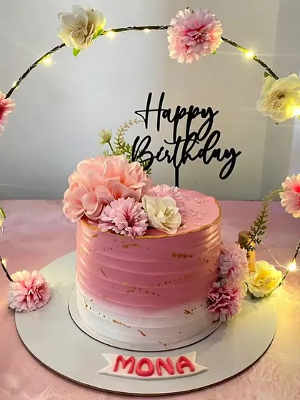 We also create beautiful cake trays to make your celebration centerpiece stand out. This pink birthday cake is surrounded by a custom ring decorated with fairy lights and flowers.