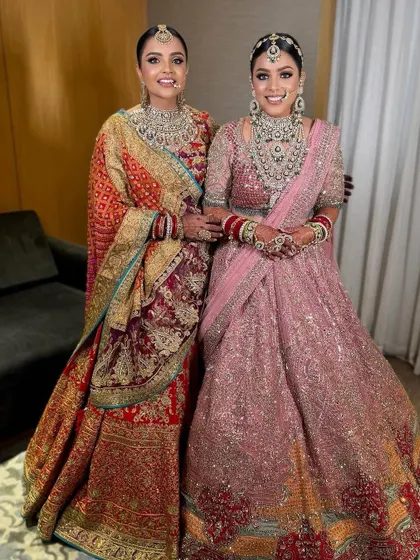 A beautiful moment between a bride and her sister, both with elegant updos.