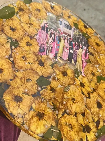 A closer look at the friendship frame, filled with vibrant yellow roses and pearls, surrounding a cherished memory of friends together.