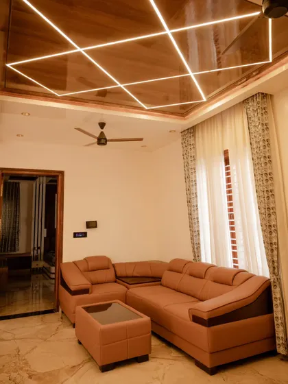 This living room ceiling features a geometric pattern of profile lighting, creating a modern and visually interesting lighting design that is fully dimmable.