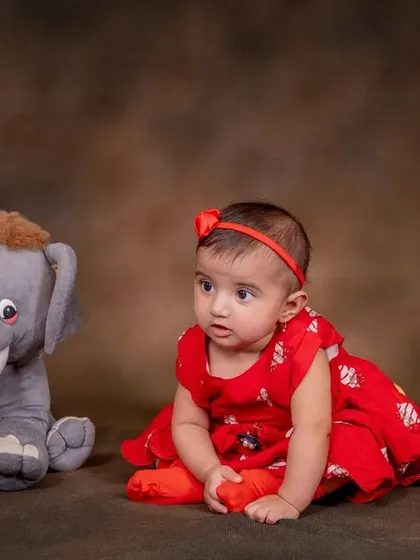 A bundle of joy surrounded by her favorite cuddly toys.