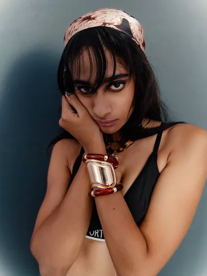 An intimate close-up that focuses on the model's face and the details of her accessories.