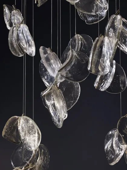 A studio shot of the Bocci 141 series against a black background, highlighting the intricate details and unique shapes of each pendant.