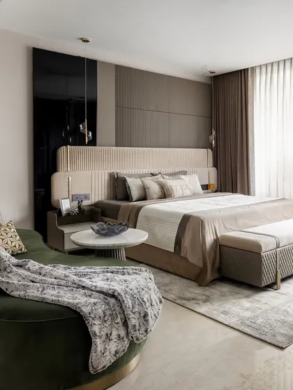 This son’s bedroom is a personal retreat, layering soft neutrals with plush textures and sculptural elements. The deep green curved lounger adds a bold, grounding contrast, making it more than just a room to sleep in.