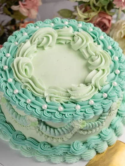 I am obsessed with bringing back classic designs. This cake features intricate, vintage-style Lambeth piping in a beautiful Tiffany blue buttercream over a rich dark chocolate ganache cake. It's elegance you can eat.