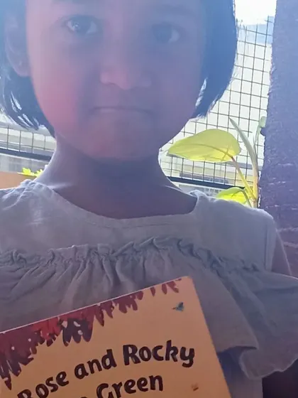 A student with her book, "Rose and Rocky Go Green."
