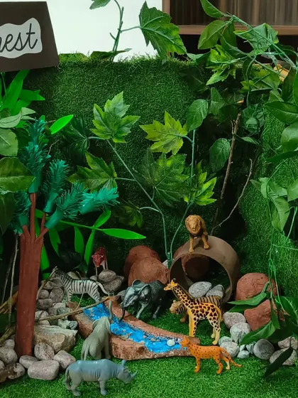 This forest diorama, complete with animals and a flowing river, was a collaborative project. It's a wonderful way for children to learn about different ecosystems and the animals that inhabit them.