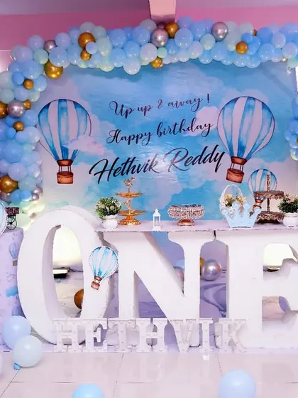 Up, up, and away! A dreamy hot air balloon theme for Hethvik's first birthday. We used a sky-blue backdrop, a large "ONE" table, and hot air balloon props to create a sense of adventure.
