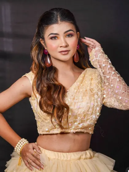 A close-up of the sequined blouse from the multi-colored tiered lehenga. The delicate net sleeve with a lattice pattern adds a touch of modern elegance to this playful outfit.