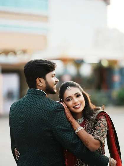 A stunning portrait of Dr. Saruna, resting her head on her groom's shoulder. Her makeup is flawless, and her expression is full of love and happiness.