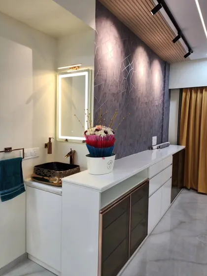 A view of the dining area console, featuring a backlit mirror and a custom-built storage unit with smoked glass doors.