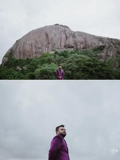 A dramatic wide shot of the groom standing alone against a massive rock formation, creating a powerful and solitary portrait.