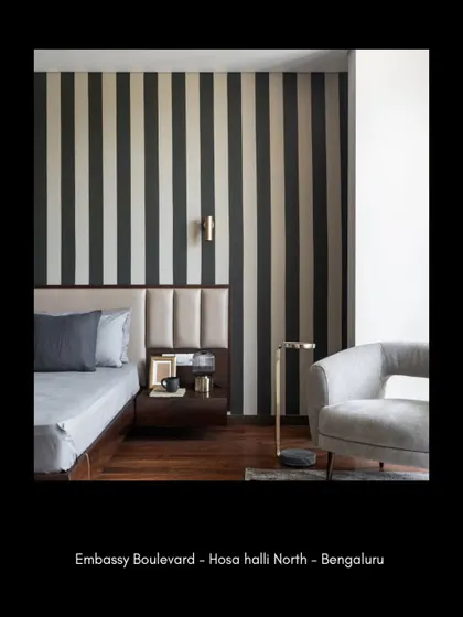 A closer look at the bedroom reveals how we layer textures and materials. The combination of a leather-paneled headboard, a bold wallpaper, and a sleek side table creates a composition that is both visually rich and functionally sound, perfect for a restful escape.