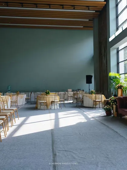 The seating arrangement for the indoor Mehendi, with elegant chairs and tables set up in the spacious hall.