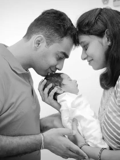 A black and white version of a classic pose, showing the parents gazing lovingly at their newborn baby.