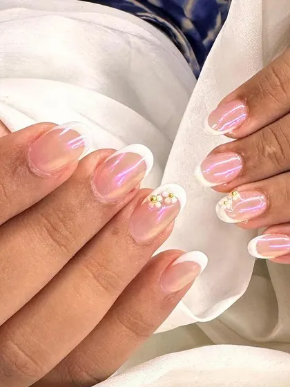 A different angle of the pearly flower accent on a classic French manicure. The iridescent base gives the nails a beautiful, healthy glow.