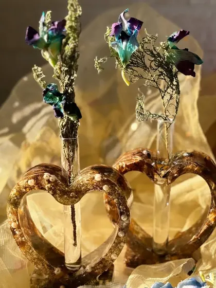 A different take on flower preservation. These heart-shaped resin vases hold a small glass vial, perfect for a single stem. The base is made from the couple's preserved wedding flowers.