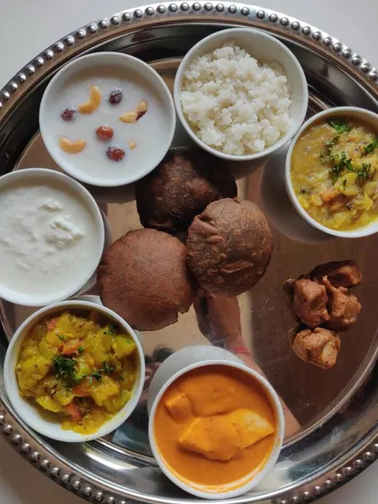 A complete Navratri special thali. This platter includes a variety of fasting-appropriate dishes like Kuttu ki Poori, Samak rice, and paneer curry, all prepared without onion or garlic.