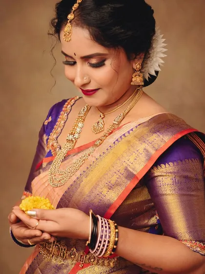 I love capturing the small, gentle moments. This close-up on her hands holding flowers shows the intricate jewelry and the beautiful texture of the saree's fabric.