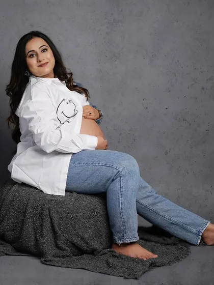 A relaxed and happy solo portrait in a casual, fun outfit, showing that maternity shoots can be comfortable and stylish.