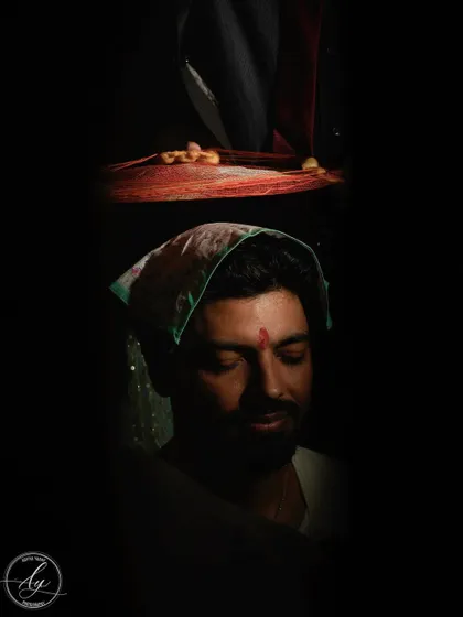An artistic and moody portrait of the groom during a wedding ritual. The low-key lighting creates a sense of solemnity and introspection, highlighting the importance of the ceremony.