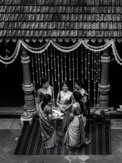 A black and white photograph of the bride with her family during a traditional ritual. This timeless processing emphasizes the emotion and the classic beauty of the scene.