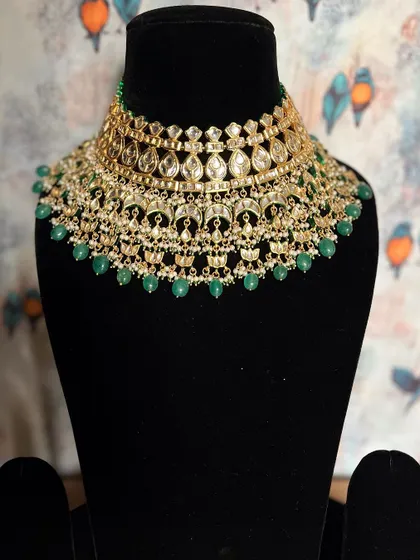 An ode to timeless elegance. This Kundan choker with green pearl drops is a magnificent piece that adds a touch of royalty to your wedding attire.