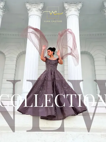 A dramatic shot of a model in a mauve ball gown with flowing cape sleeves. This is a true statement piece for any grand event.