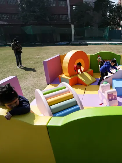 A wide shot showing kids enjoying every corner of the play area, from the tunnel to the climbers.
