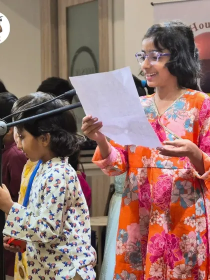 Confidence in the making. Here, a young student proudly shares her work with her friends. We encourage every child to find their voice and express themselves freely.