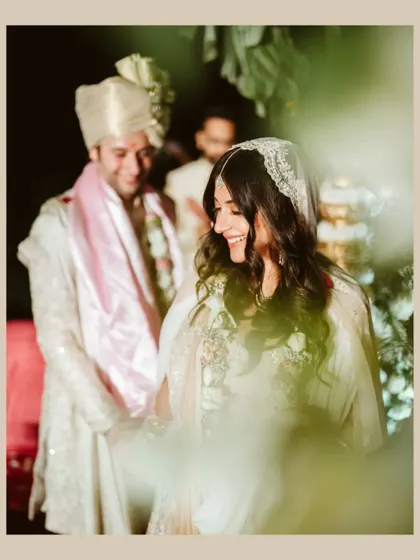 A beautiful, candid shot of the bride, her smile captured through the foliage. This image feels natural and full of joy.