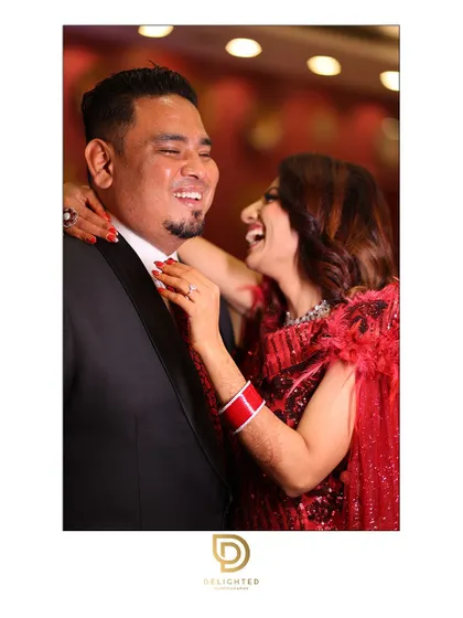A moment of pure, uninhibited laughter between a couple during their celebration. This candid shot perfectly captures the joy and fun of the event.