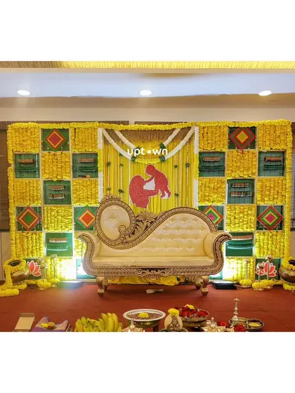 A baby shower stage with a yellow checkerboard backdrop and a traditional silhouette prop.