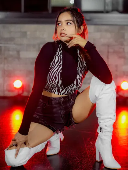A different pose from the red-lit series, capturing movement and attitude.