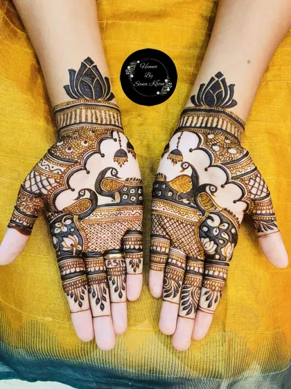 A vibrant and beautiful design with two peacocks facing each other, surrounded by jhumka (earring) motifs and topped with a lotus.