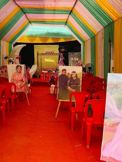 The entrance walkway of a baby shower, lined with the couple's maternity photos on easels for a personal touch.