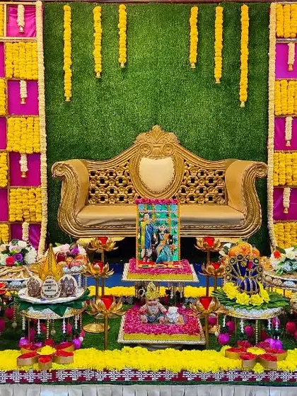A colorful baby shower setup with a green, yellow, and pink marigold backdrop, creating a bright and cheerful atmosphere.