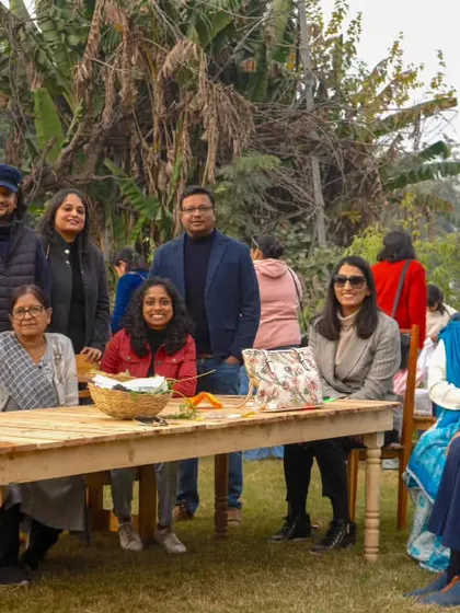 A large family group gathered around a wooden table for a meal, enjoying quality time together.