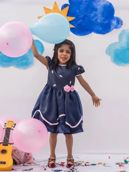 Ready for a party with balloons and smiles. This navy blue dress with pink accents is both playful and chic, making it a versatile choice for birthdays and other celebrations.