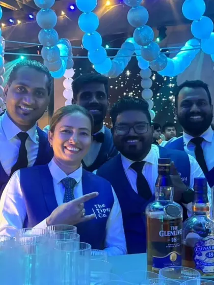 Our team in blue vests, posing behind the bar. We coordinate our uniforms to match the event's color scheme, adding to the polished and cohesive look.