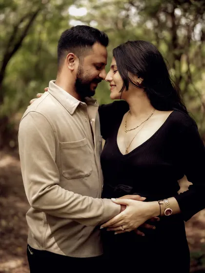 An intimate close-up of the couple, nose-to-nose, sharing a quiet moment of connection in the woods.