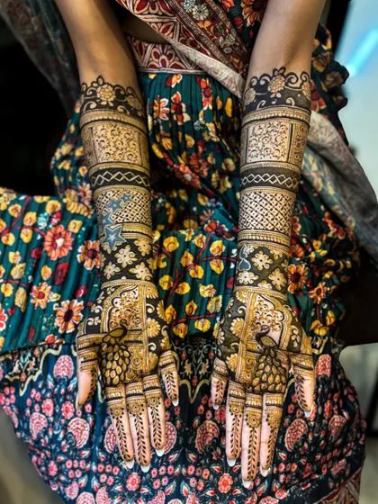 A beautiful and flawless bridal design for Manjusha, featuring intricate peacock motifs and detailed pattern work that covers the hands completely.