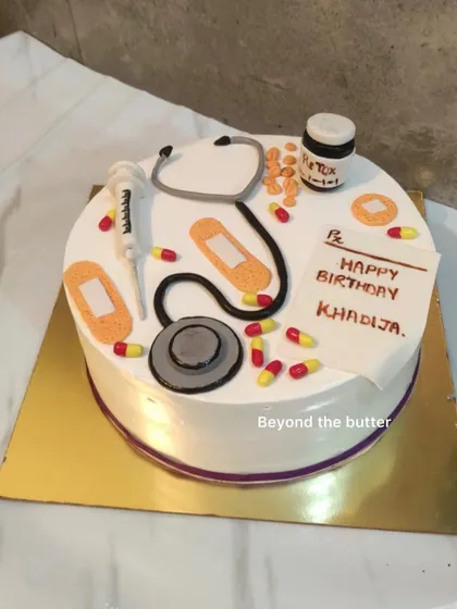 A cake to celebrate a doctor's birthday. It's decorated with all sorts of medical items made from fondant, like a stethoscope, syringe, pills, and a prescription pad.